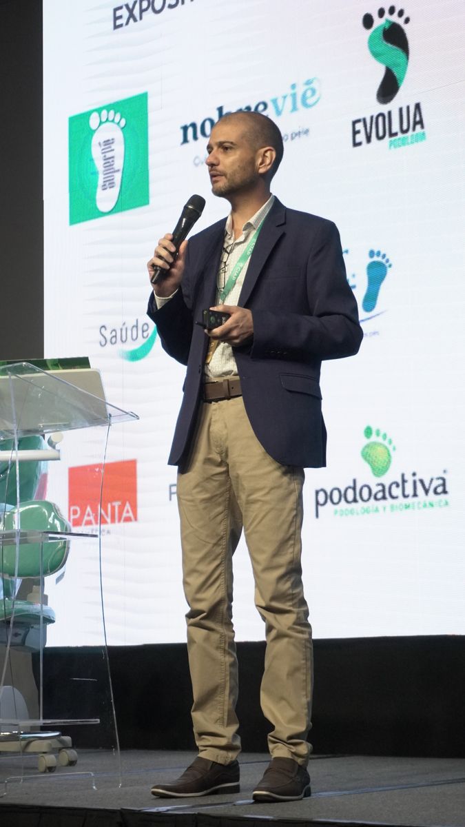 Palestrante no palco do CIAP diante do painel de expositores