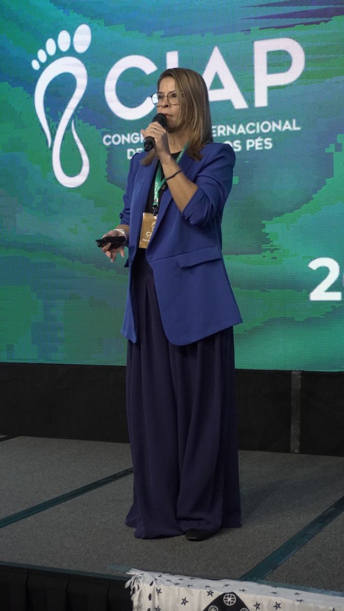 Palestrante no palco com a logo do CIAP ao fundo